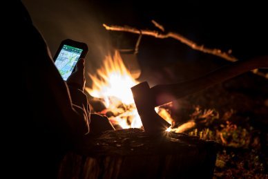 A man looking at an electronic map by the fire