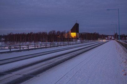 Ivalo church with warm yellow light in winter twilight